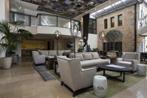 a lobby with couches and tables in a building at Harmony Hotel - an Atlas Boutique Hotel in Jerusalem