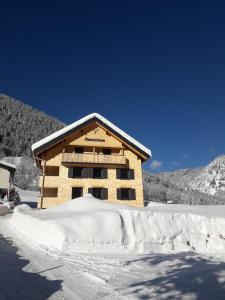 a building covered in snow with a pile of snow at Haus Amatschon in Brand