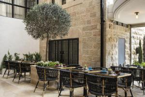 restauracja ze stołami i krzesłami oraz ceglaną ścianą w obiekcie Harmony Hotel - an Atlas Boutique Hotel w Jerozolimie