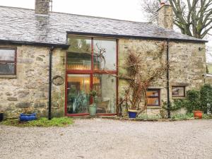 an old stone house with a large window at Haworth Barn in Stainforth