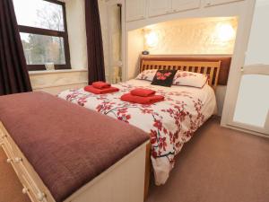 a bedroom with two beds with red pillows on them at Haworth Barn in Stainforth