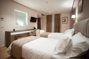 a hotel room with two beds and a window at Doanesia Premium Hotel & Spa in Tirana