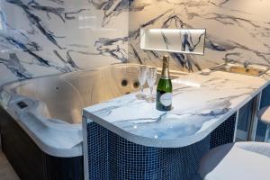 a bathroom with a tub and a bottle of champagne at Mischief Liverpool in Liverpool