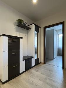 een kamer met een keuken met zwart-witte kasten bij Elegant Escape apartment II - City Centre in Bratislava