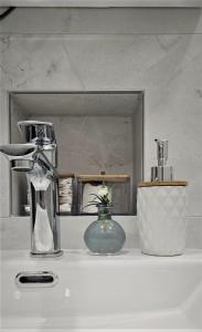 a counter top with two vases and a mirror at Moonrise Apartment in Mostar