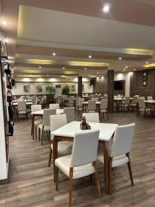 a dining room with white tables and white chairs at Apartments & Restaurant Despina in Prilep