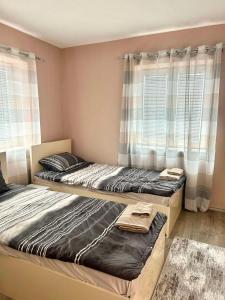 two twin beds in a room with windows at Apartments & Restaurant Despina in Prilep