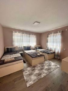 een kamer met 3 bedden en 2 ramen bij Apartments & Restaurant Despina in Prilep