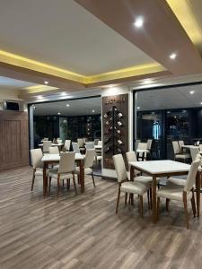 een restaurant met witte tafels, stoelen en spiegels bij Apartments & Restaurant Despina in Prilep