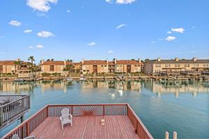 a deck with a chair on a dock in the water at Water View Wonder in Padre Island