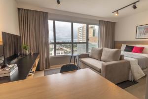 een hotelkamer met een bed en een bank bij Housi - Metropolitan Sidney Smart Style in Goiânia