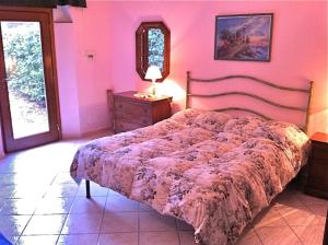 a bed in a bedroom with a pink wall at Agriturismo Campo Al Sole in Castell’Anselmo