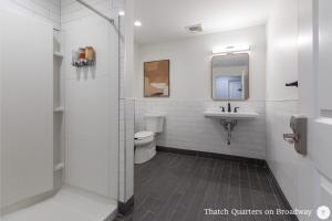 a bathroom with a toilet and a sink and a mirror at West Broadway Quarters by Thatch in Boston