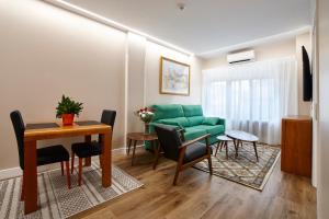 a living room with a green couch and a table at Zenit Dos Infantas in Zamora