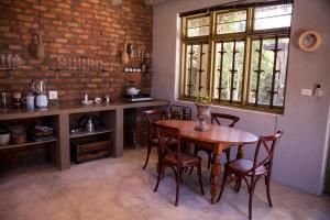 a table and chairs in a room with a brick wall at The Onion Cottage in Nieu-Bethesda