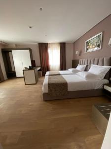 a large bedroom with a large bed with white pillows at Doanesia Premium Hotel & Spa in Tirana