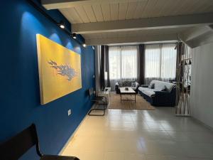 un salon avec un mur bleu dans l'établissement THE LOFT PROJECT BY DIMITROPOULOS, à Aigio