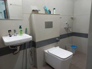 a bathroom with a sink and a toilet and a mirror at Nature 2BHK AC Villa - Trivandrum in Trivandrum +27 photos