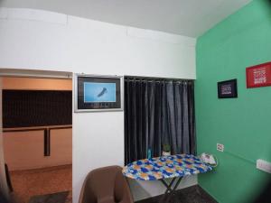 a room with a table and a tv on the wall at Nature 2BHK AC Villa - Trivandrum in Trivandrum