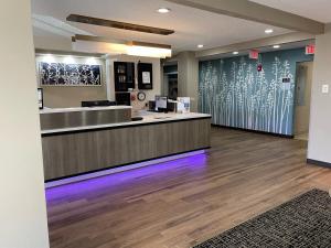 a lobby with a reception desk and a counter with purple lights at Baymont by Wyndham Boardman in Boardman