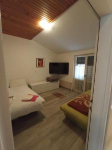 a bedroom with a bed and a flat screen tv at Apartments Timi in Poreč