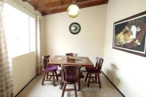 a dining room with a table and chairs and a clock at Cabañita Central en Tunja in Tunja