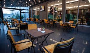a dining room with tables and chairs in a restaurant at Doanesia Premium Hotel & Spa in Tirana
