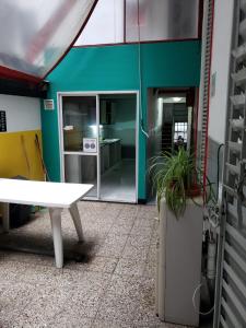 una oficina con una mesa blanca y una pared verde en Tinta Roja Residencia Estudiantil en Buenos Aires