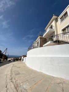 a white building with a balcony on the side of a street at Coral View in Peyia