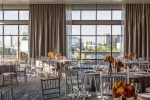 a banquet room with tables and chairs and windows at Kimpton Aertson Hotel by IHG in Nashville