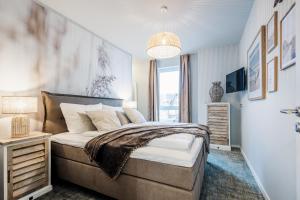 a bedroom with a bed and a large window at Baltic Lagoon Resort direkt am Meer in Fuhlendorf