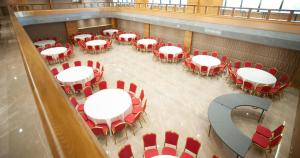 an overhead view of a room with white tables and red chairs at Doanesia Premium Hotel & Spa in Tirana