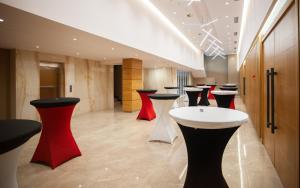 Doanesia Premium Hotel & Spa في تيرانا: لوبي مع صف من الكراسي الحمراء والسوداء