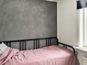 1 dormitorio con 1 cama con manta rosa en Holiday home MULLHYTTAN II, en Mullhyttan