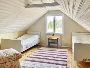 um quarto no sótão com 2 camas e uma janela em Holiday home HÖGSBY II em Högsby