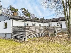 ein weißes Haus mit einem Holzzaun davor in der Unterkunft Holiday home YNGSJÖ III in Yngsjö