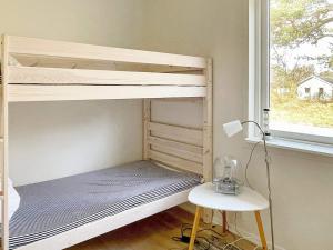 a bedroom with a bunk bed with a desk and a window at Holiday home YNGSJÖ III in Yngsjö