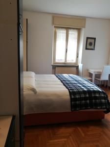 a bedroom with a bed and a window and a table at Falco Bianco in San Daniele del Friuli