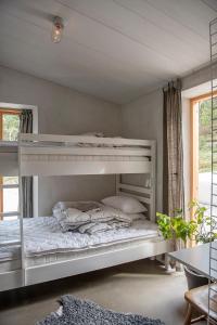 a white bunk bed in a room with a window at Bergshuset in Visby