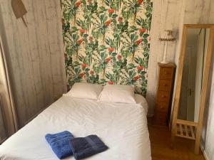 a bed with two towels on it in a bedroom at La Maison des Palombes in Francheville