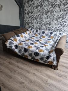 Una cama en una habitación con una manta. en La Belle Evasion, en Gamaches