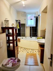 a bathroom with a tub and a sink and a bath tub at Ferienhaus Alt Bahnhaus in Ruschberg