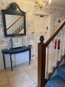 a hallway with a blue table and a mirror at Downsfield Bed and Breakfast in St Ives