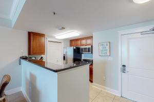 a kitchen with a counter and a refrigerator at Waterscape B603 in Fort Walton Beach
