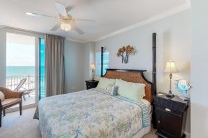 a bedroom with a bed and a balcony with the ocean at Waterscape B603 in Fort Walton Beach