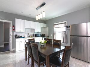 cocina con mesa, sillas y nevera en The Prospect Point Penthouse- Yard & Parking, Minutes From Falls & Casino by Niagara Hospitality, en Niagara Falls