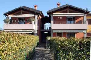 uma casa com duas varandas e uma sebe em CASA VACANZE DA RIKI APPARTAMENTO 2 em Peschiera del Garda