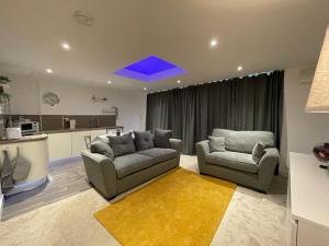 a living room with two couches and a kitchen at Newbus Grange Lodge The Cottage in Darlington