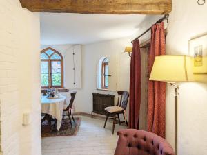 a living room with a table and a window at Truffle Cottage, Chichester in Chichester