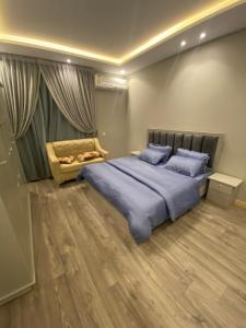 a bedroom with a large bed with blue pillows at شقة غرفتين وصاله دخول ذاتي in Riyadh